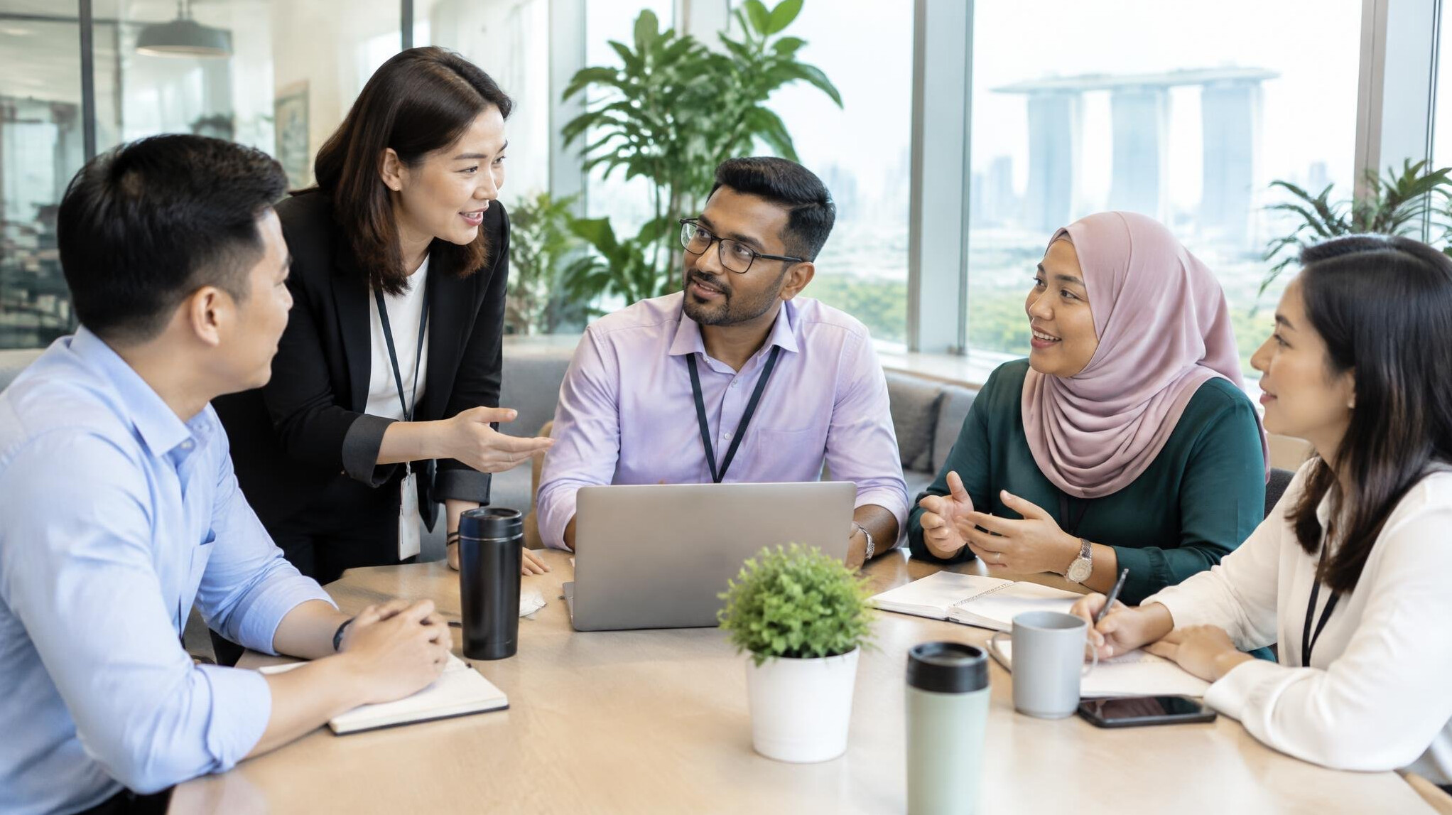 Diverse Singaporean corporate team meeting in a bright office
